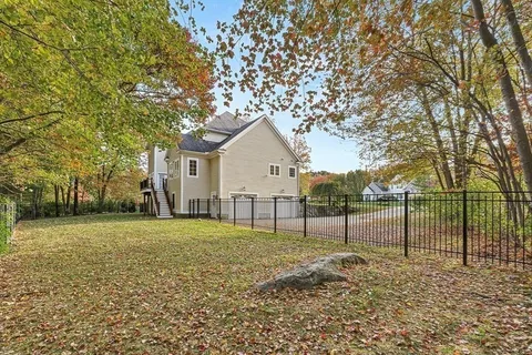 a view of white house with a yard and large tree