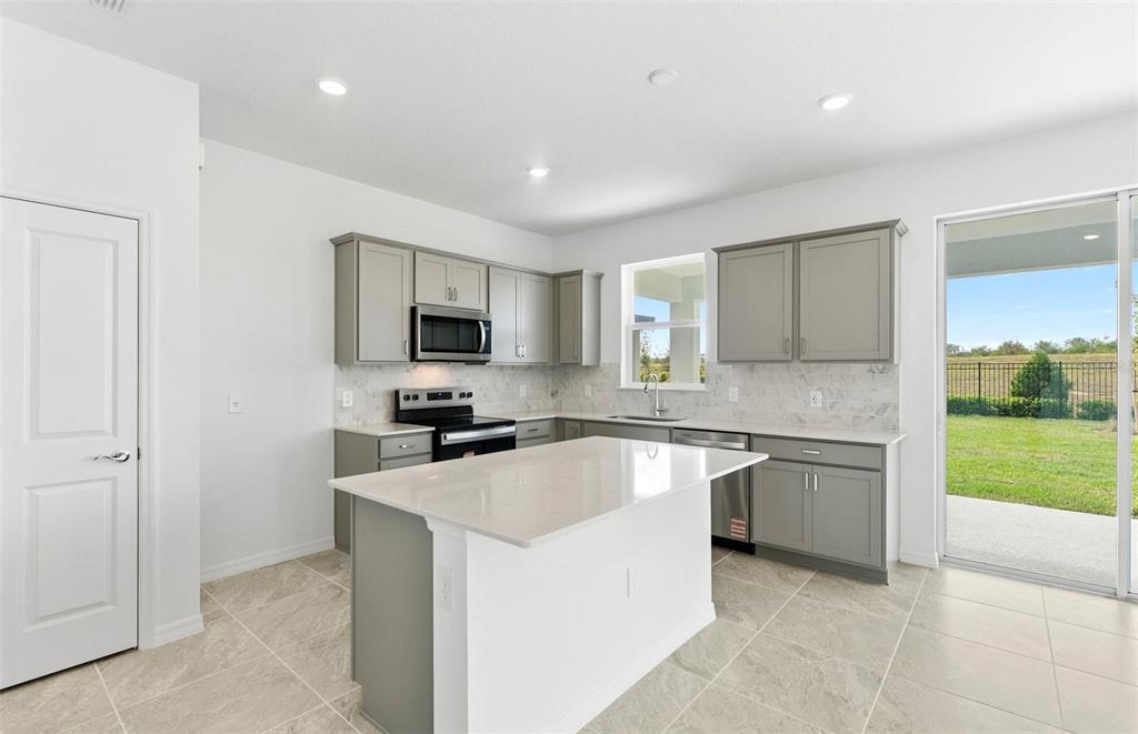 1277 Lakeridge Way Lake Lake Alfred, FL 33850 - Photo 2 of 29 a kitchen with stainless steel appliances granite countertop a sink and a stove