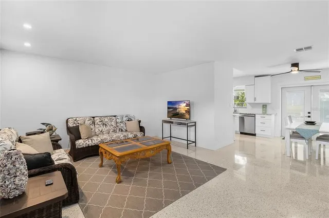 a living room with furniture and a dining table with kitchen view
