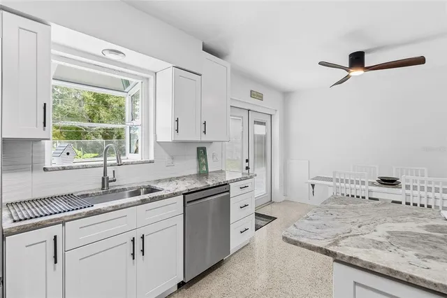 a kitchen with stainless steel appliances granite countertop a sink stove and cabinets