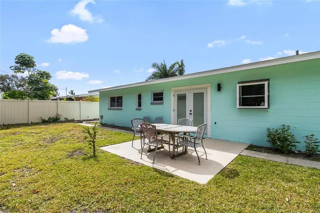 a view of a house with backyard and sitting area