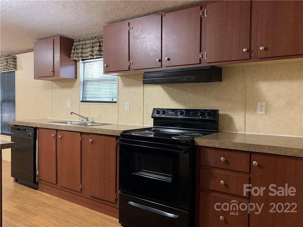 175 Mosley Road Blacksburg, SC 29702 - Photo 14 of 23 a kitchen with granite countertop cabinets and black appliances