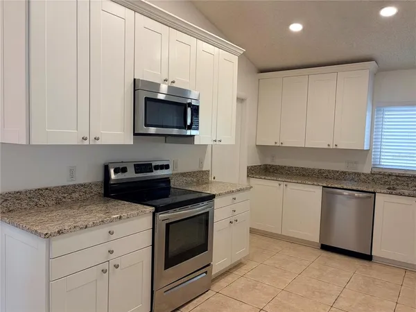 a kitchen with stainless steel appliances granite countertop a refrigerator and a sink