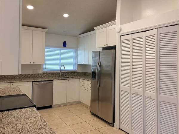a kitchen with stainless steel appliances granite countertop a refrigerator and a sink