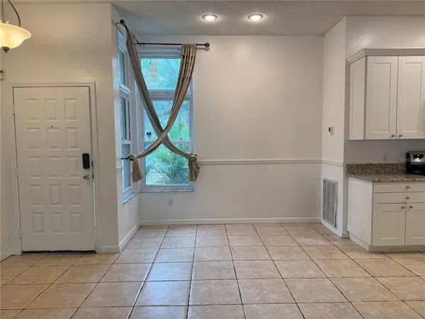 a room with kitchen island sink refrigerator and cabinets