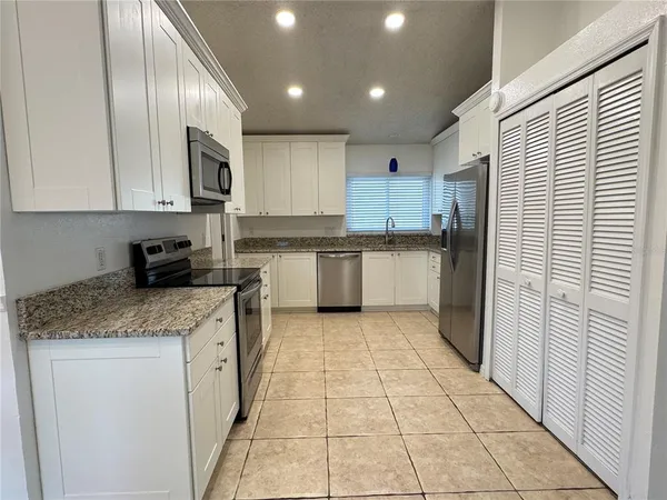 a kitchen with granite countertop white cabinets and sink