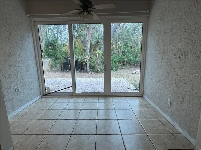 a view of an empty room and window ceiling fan