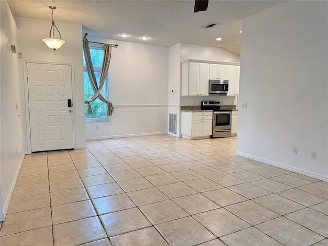 a view of kitchen with stainless steel appliances kitchen island granite countertop a refrigerator and a sink