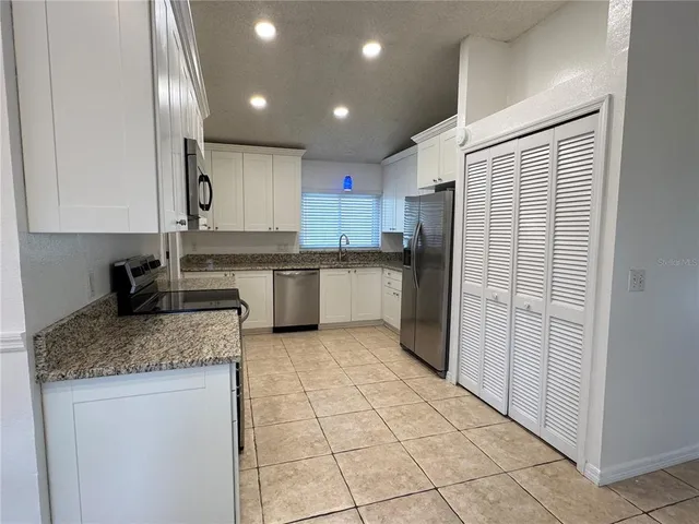 a kitchen with stainless steel appliances granite countertop a refrigerator and a sink
