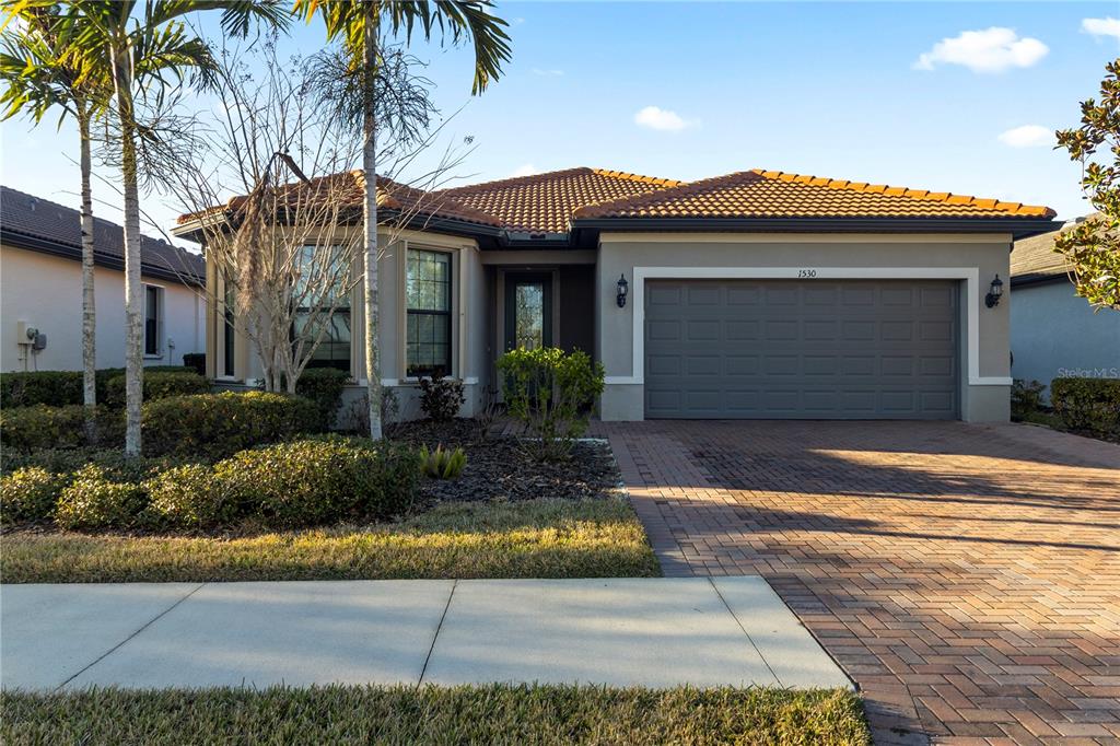 1530 Hyssop Loop North Port, FL 34289 - Photo 1 of 53 a front view of a house with a yard and potted plants
