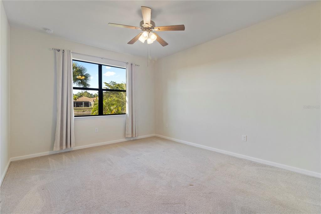 1530 Hyssop Loop North Port, FL 34289 - Photo 25 of 53 an empty room with windows and chandelier fan