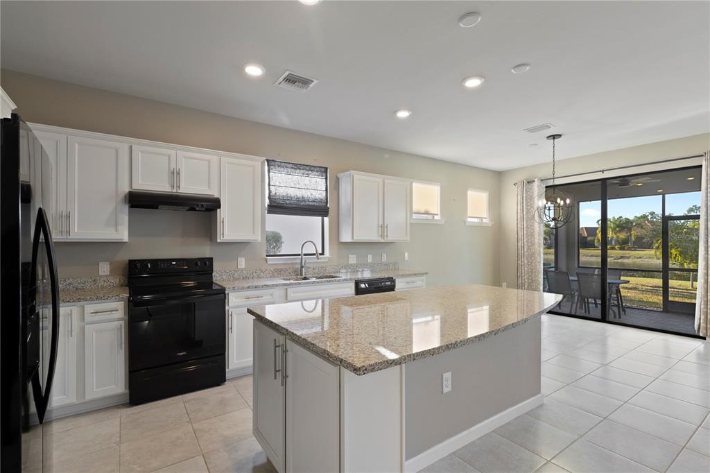 1530 Hyssop Loop North Port, FL 34289 - Photo 7 of 53 a large kitchen with stainless steel appliances granite countertop a sink and a stove