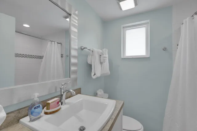 a view of a patio with dining table and chairs under an umbrella with large trees