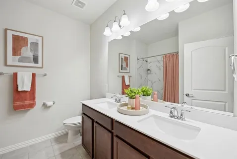 a bathroom with a double vanity sink mirror and toilet