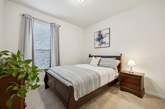 a bedroom with bed and a potted plant