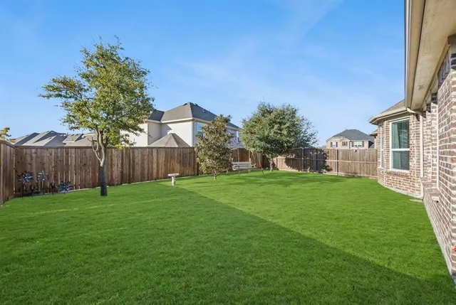 a view of a backyard with table and chairs and wooden fence