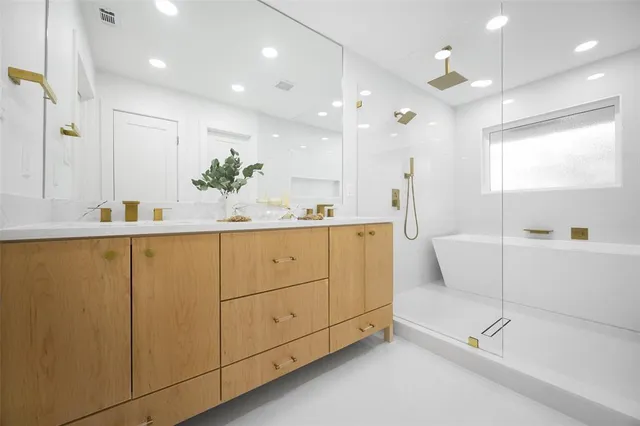 a bathroom with a tub a sink and mirrors
