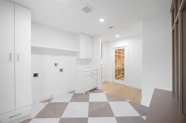 a view of a utility room with cabinets