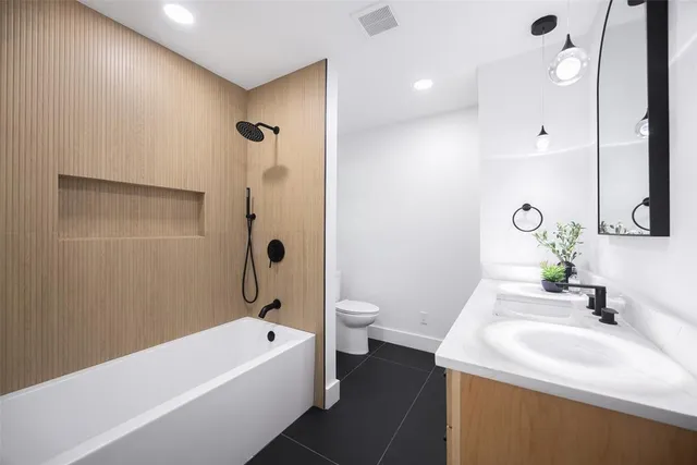 a bathroom with a double vanity sink toilet and shower