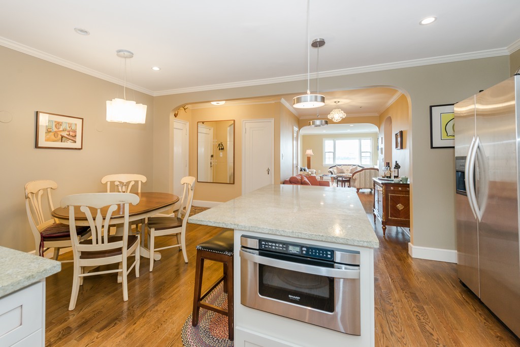 280 Beacon Street, Unit 65 Boston, MA 02116 - Photo 5 of 15 a kitchen with stainless steel appliances granite countertop a table chairs and a refrigerator