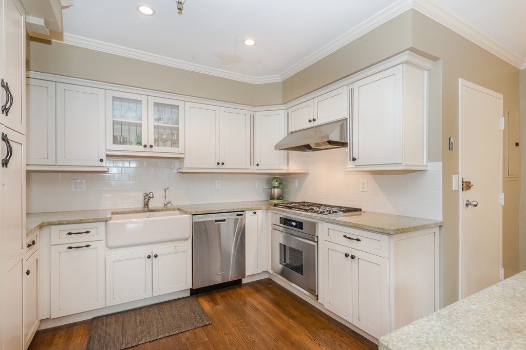 280 Beacon Street, Unit 65 Boston, MA 02116 - Photo 7 of 15 a kitchen with stainless steel appliances granite countertop white cabinets stove a sink and dishwasher