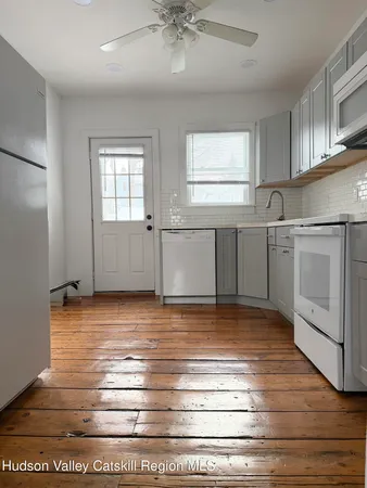 a view of a livingroom with an empty space & wooden floor