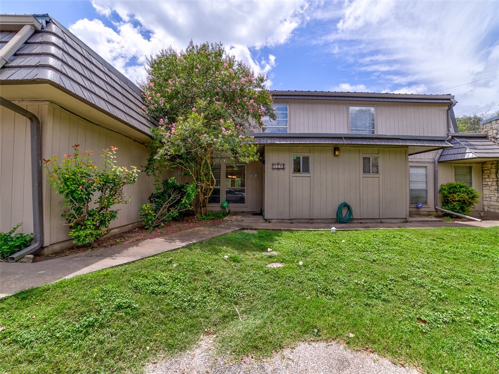 a view of house with backyard and garden