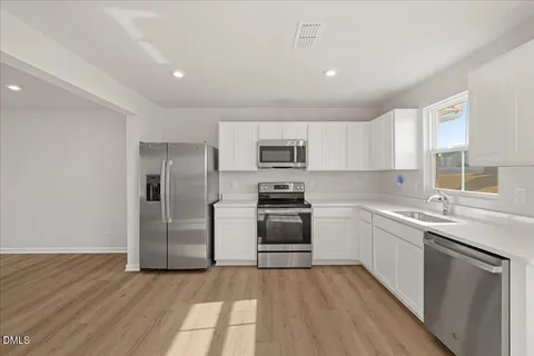 a kitchen with a sink cabinets stainless steel appliances and a window
