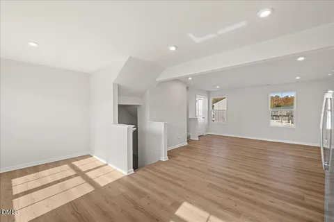 a view of empty room with wooden floor