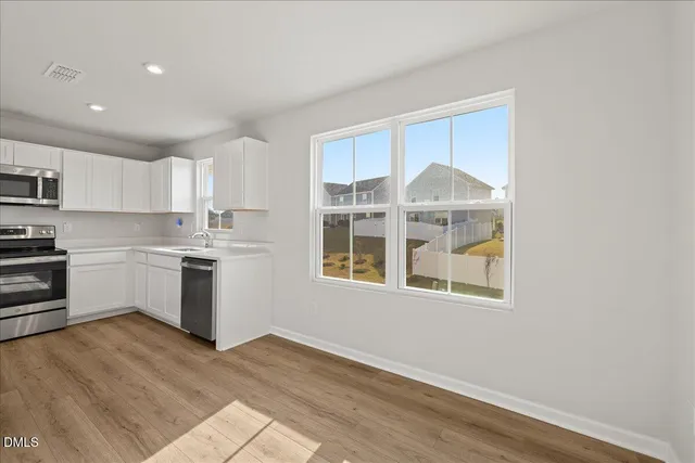 a kitchen with granite countertop white cabinets and white appliances