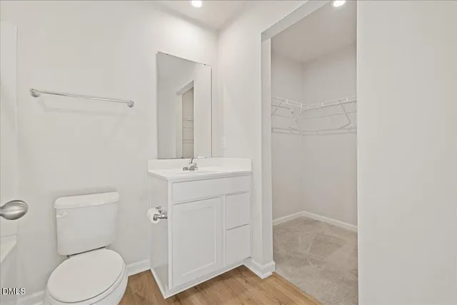 a bathroom with a toilet sink vanity and mirror
