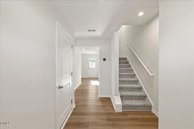 a view of a hallway with wooden floor and entryway