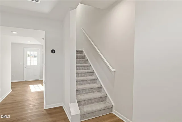a view of a hallway with wooden floor and entryway