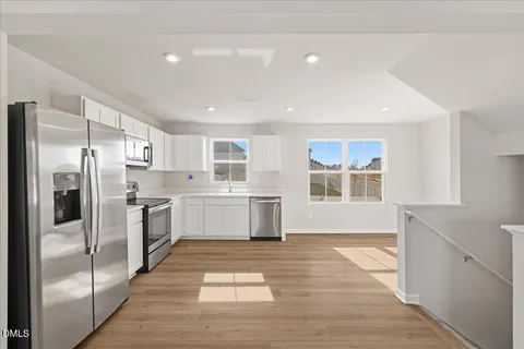 a kitchen with white cabinets and stainless steel appliances