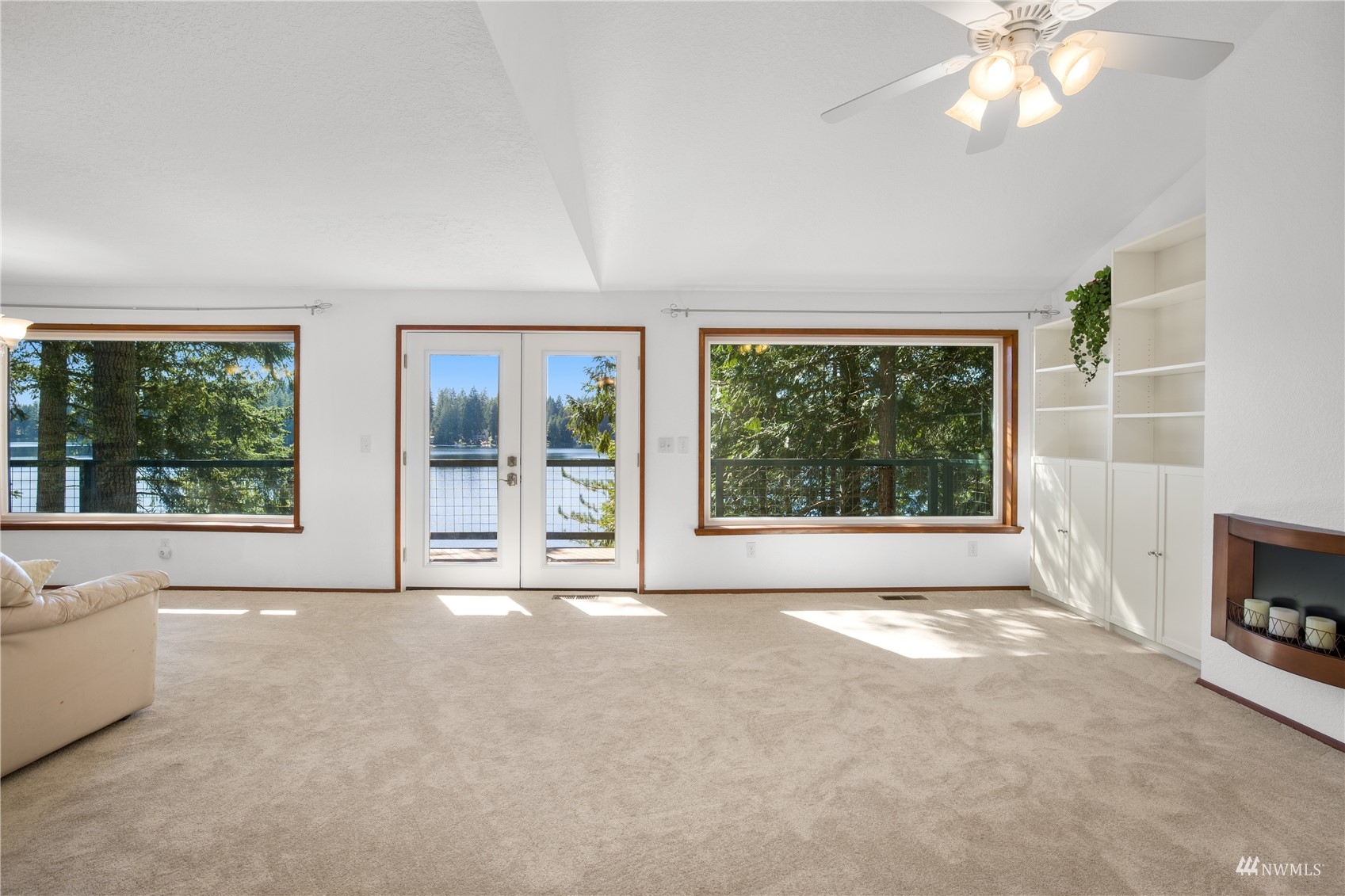 2141 Mason Benson Road East Grapeview, WA 98546 - Photo 16 of 40 a view of a livingroom with a fireplace a ceiling fan and a large window