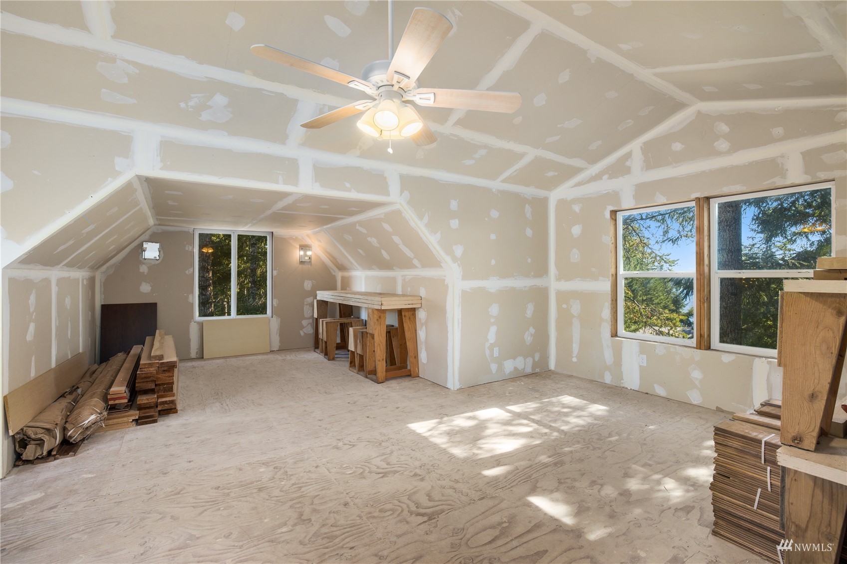 2141 Mason Benson Road East Grapeview, WA 98546 - Photo 35 of 40 a view of a livingroom with a fireplace a ceiling fan and windows