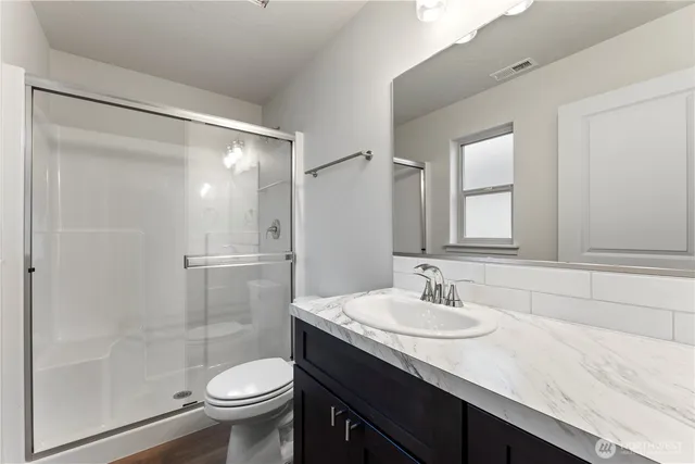 a bathroom with a sink a toilet and shower