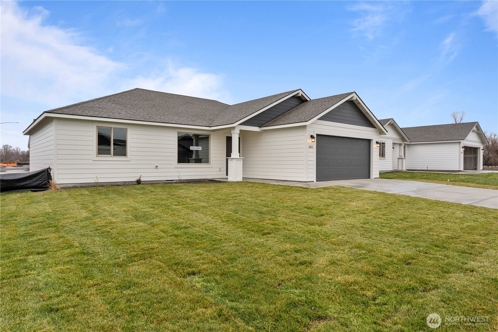 202 North Sandy Loop Moses Lake, WA 98837 - Photo 22 of 24 a front view of house with yard and trees in the background