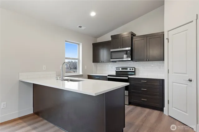 a kitchen with granite countertop stainless steel appliances and wooden cabinets