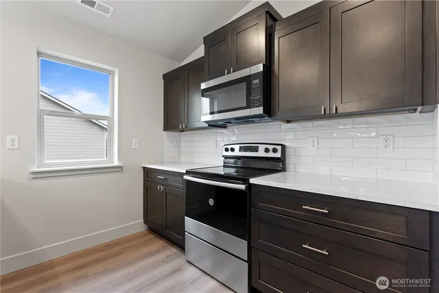 a kitchen with stainless steel appliances granite countertop a sink and a microwave