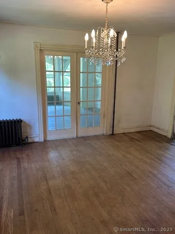 a view of a chandelier in big room with windows and chandelier