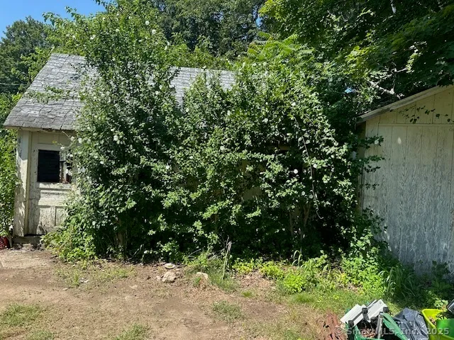 a view of a wooden house with a tree