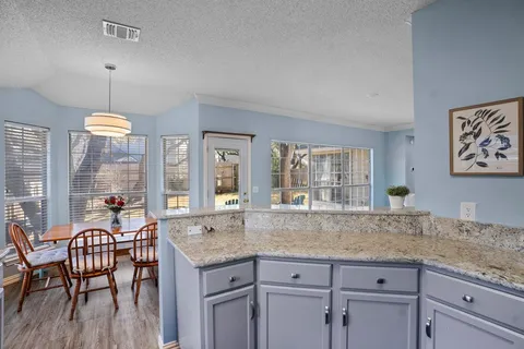 a kitchen with granite countertop a refrigerator and a sink