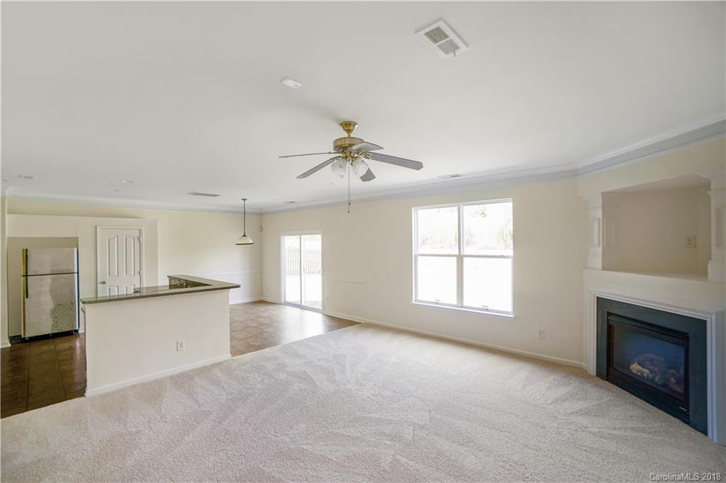 12918 Rothe House Road Charlotte, NC 28273 - Photo 15 of 25 a view of a kitchen and empty room with windows cabinet a fireplace