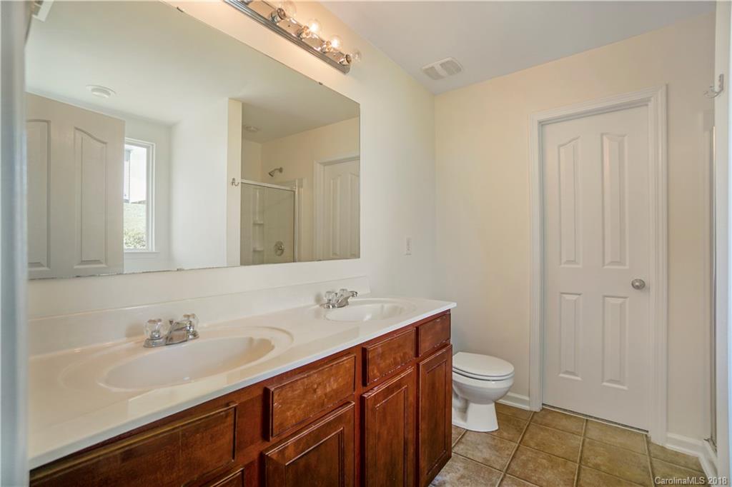 12918 Rothe House Road Charlotte, NC 28273 - Photo 25 of 25 a bathroom with a sink a toilet and a large mirror