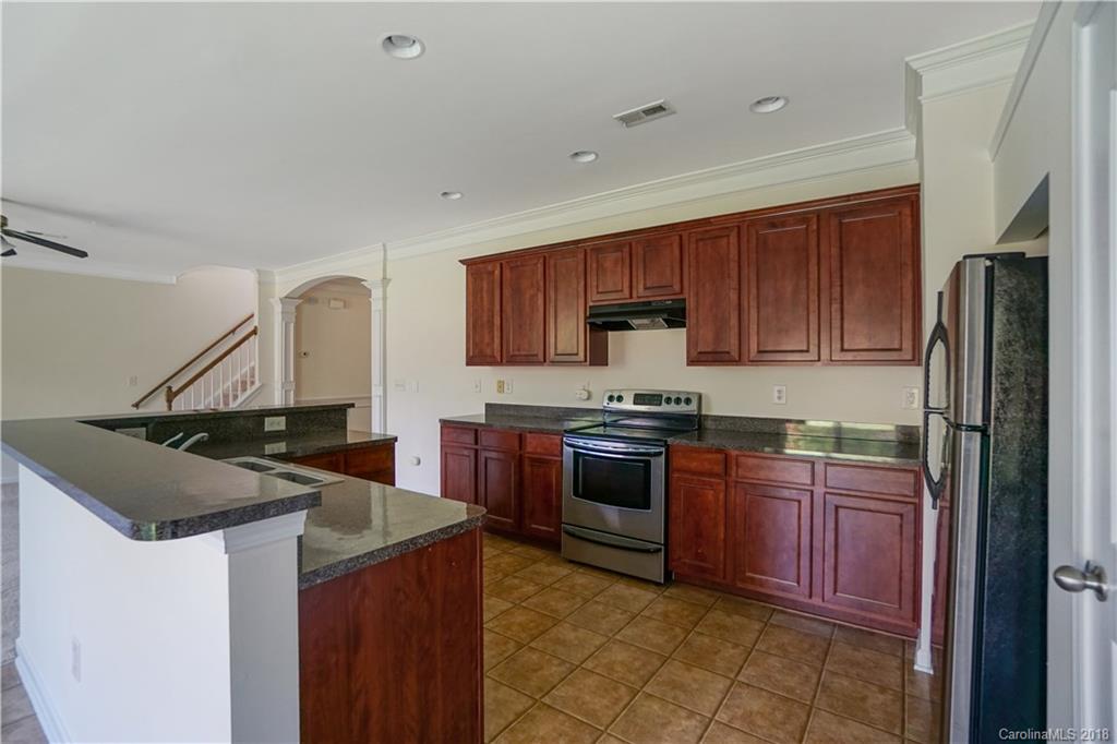 12918 Rothe House Road Charlotte, NC 28273 - Photo 5 of 25 a kitchen with stainless steel appliances granite countertop a sink stove and refrigerator