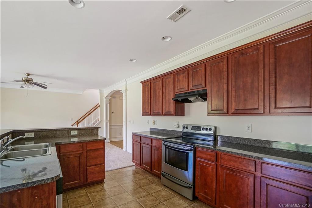 12918 Rothe House Road Charlotte, NC 28273 - Photo 7 of 25 a kitchen with wooden cabinets and a stove top oven