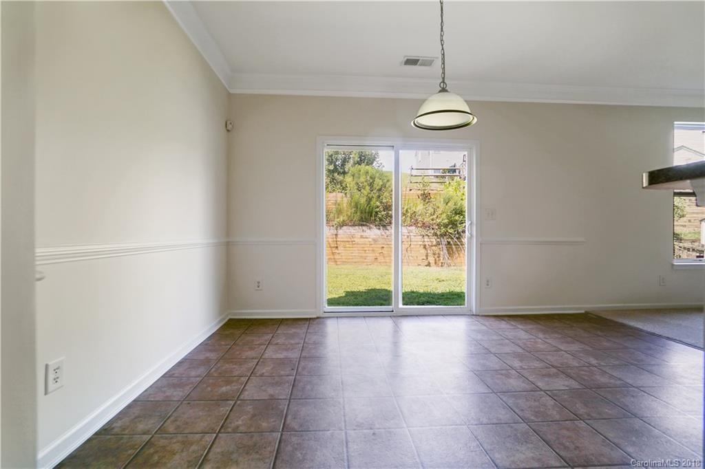 12918 Rothe House Road Charlotte, NC 28273 - Photo 9 of 25 a view of an empty room with wooden floor and a window
