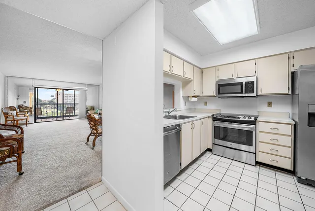a view of a dining room and livingroom with furniture wooden floor a rug and a chandelier