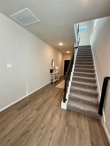 a view of a room with wooden floor and stairs